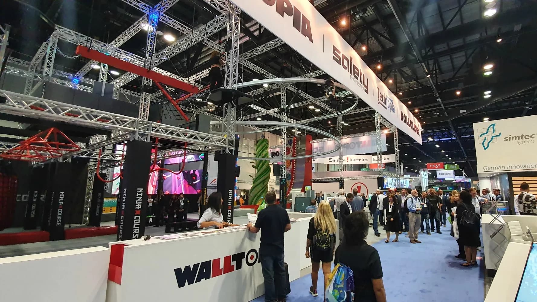 A crowd of people at the enoromous Walltopia booth at IAAPA Expo in Florida