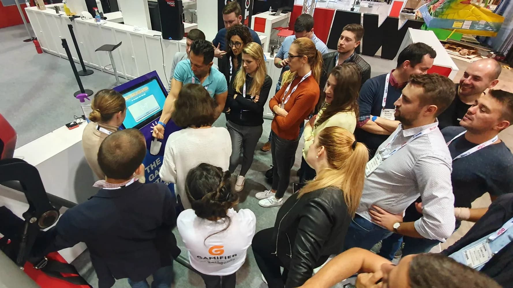A crowd of people at the Gamifier Kiosk terminal at IAAPA Expo in Florida
