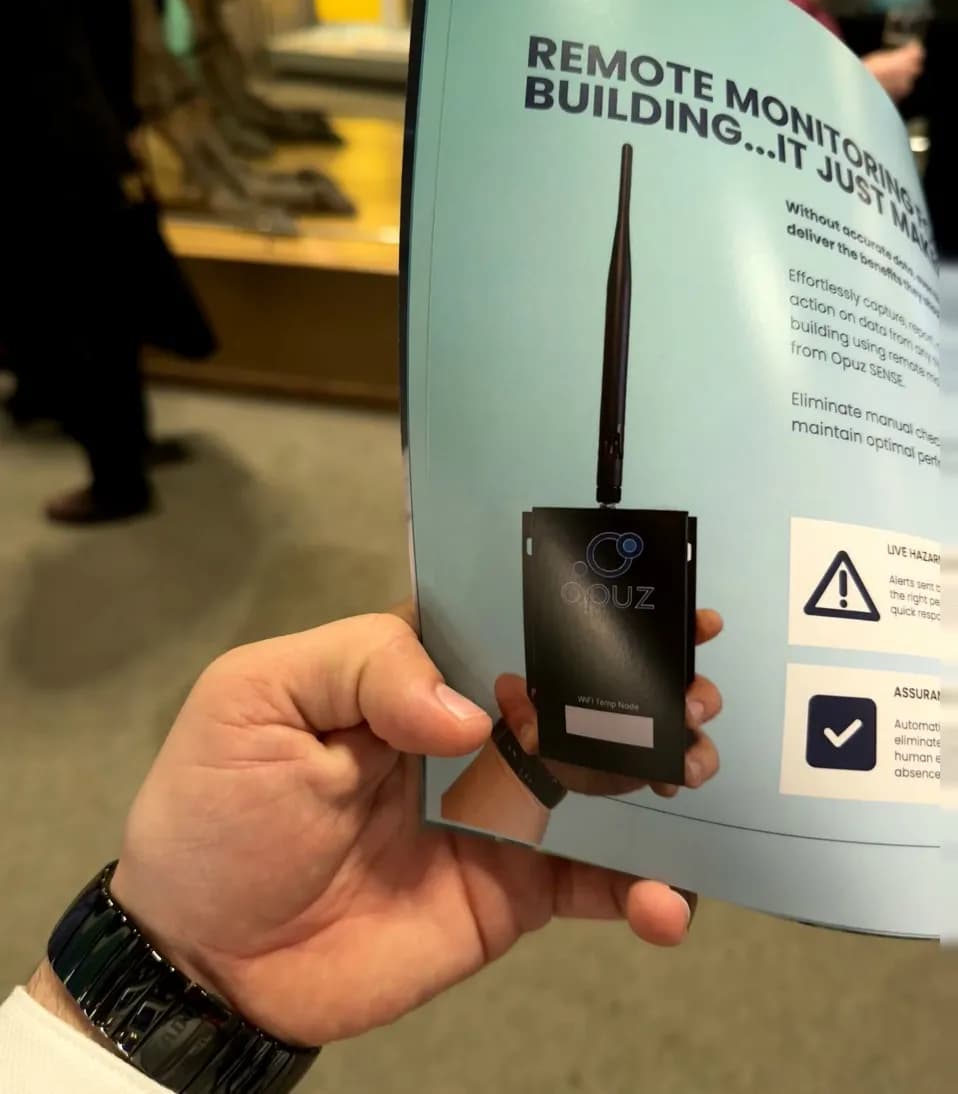 Dian Deskov`s hand holding the brochure of Opuz Compliance Software with his hand visible in the borchure